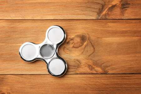 Modern spinner on wooden backgroundの写真素材
