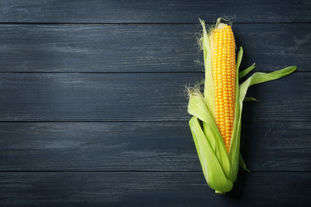 Fresh corn cob on wooden table