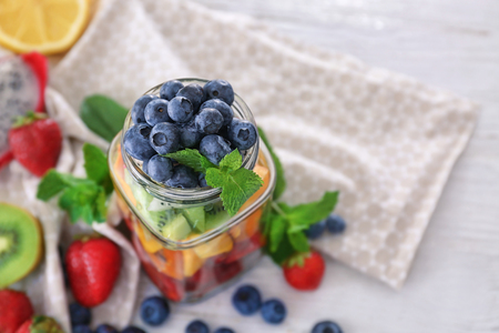 Mason jar with fruits and berries on tableの写真素材