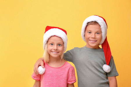 Cute children in Santa hats on color backgroundの写真素材