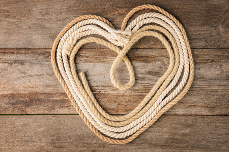 Hemp ropes in shape of heart on wooden backgroundの写真素材