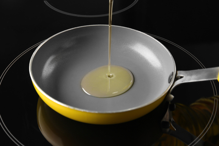 Pouring oil into frying pan, closeupの写真素材