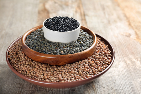 Bowls with different lentils on wooden tableの写真素材