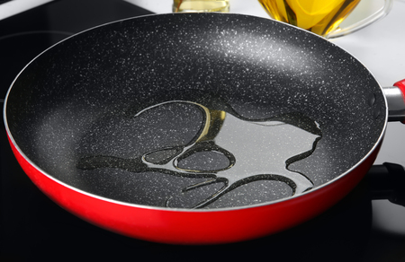 Frying pan with cooking oil on electric cookerの写真素材