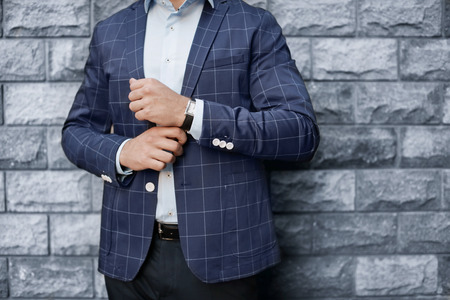 Handsome successful businessman near brick wallの写真素材