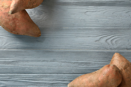 Sweet potatoes on wooden tableの写真素材