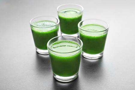 Shots of healthy wheat grass juice on grey backgroundの写真素材