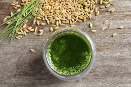 Shot of wheat grass juice on wooden tableの写真素材