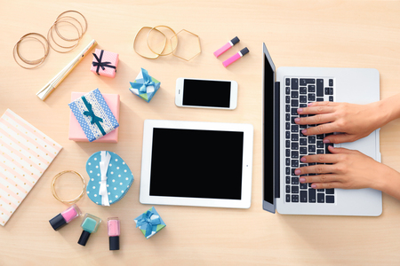 Hands of beauty blogger with laptop and different stuff on tableの写真素材