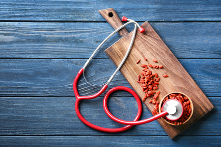 Composition with goji berries and stethoscope on wooden backgroundの写真素材