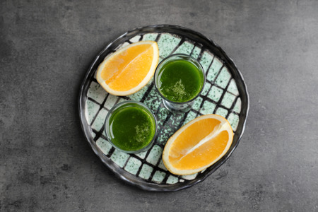 Shots of healthy wheat grass juice on plateの写真素材