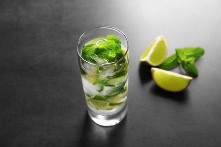 Glass of cocktail with lime and mint on grey backgroundの写真素材