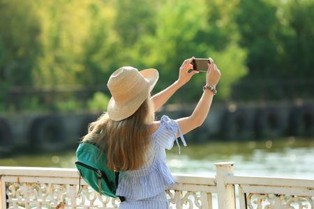 Beautiful young tourist taking photo outdoorsの写真素材