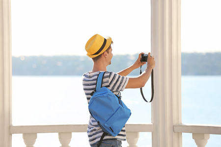 Young man taking photo outdoorsの写真素材