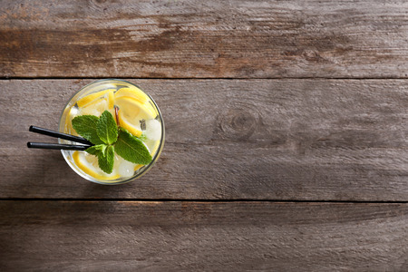 Glass of cocktail with lemon and mint on wooden backgroundの写真素材