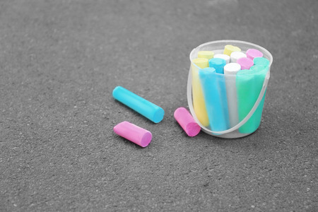 Multicolored chalk in bucket on asphaltの写真素材