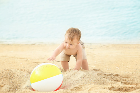 Little boy playing with ball on beachの写真素材
