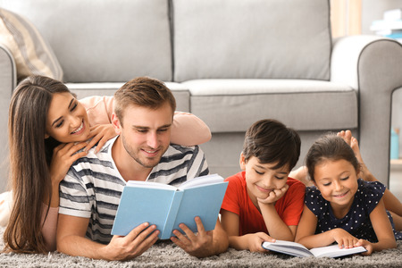 Happy family reading books at homeの写真素材