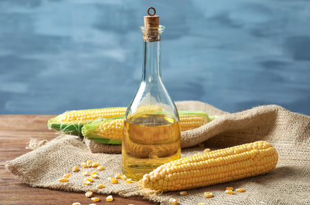 Glass bottle with corn oil on sackcloth fabric
