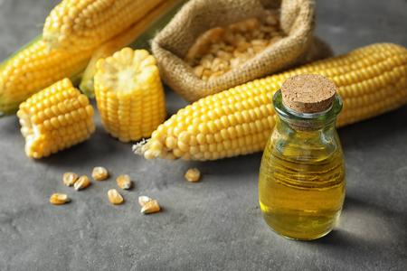 Glass jar with corn oil on grey backgroundの写真素材