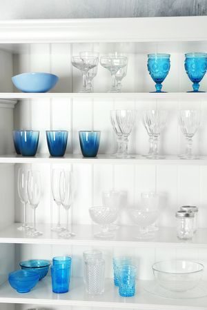 White storage stand with glassware in kitchenの写真素材