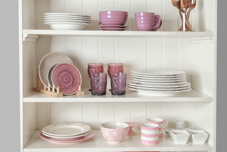 Kitchen shelving with dishware on color wall backgroundの写真素材