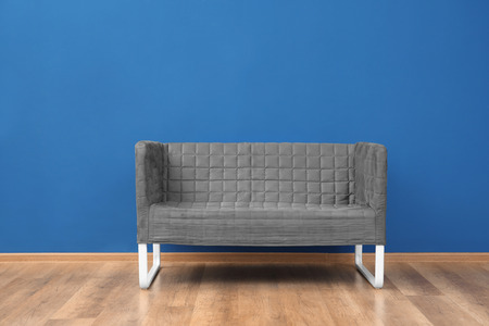 Cozy sofa on blue wall background