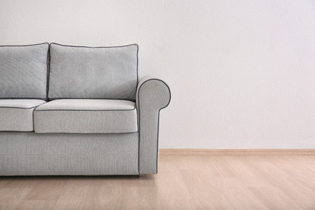 Cozy sofa on light wall background