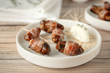 Plate with bacon wrapped dates on tableの写真素材