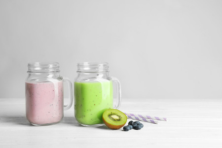 Mason jars with fresh protein shakes on table against white backgroundの写真素材