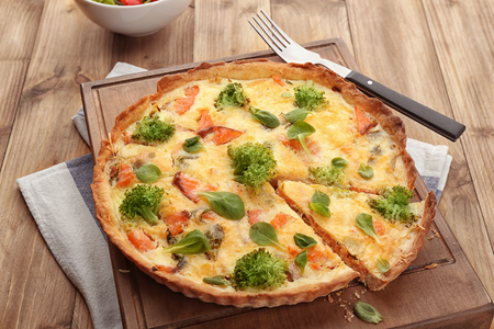 Tasty salmon quiche on wooden boardの写真素材