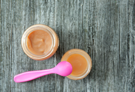 Jars with baby food on wooden tableの写真素材