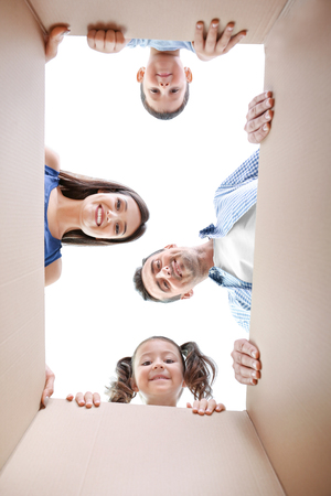 Happy family looking into cardboard boxの写真素材
