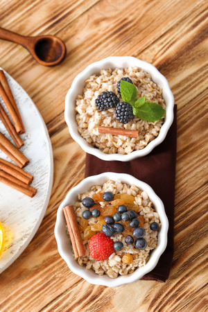 Tasty oatmeal with berries in bowls on tableの写真素材