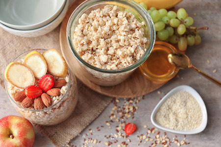 Jar and glass with tasty oatmeal on tableの写真素材