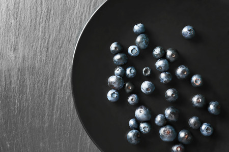 Plate with fresh acai berries on tableの写真素材