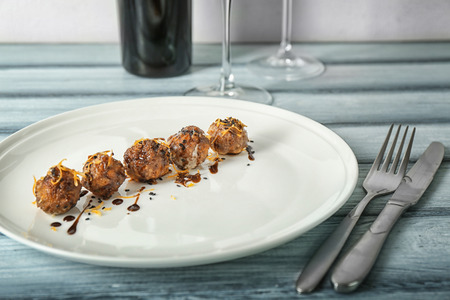 Plate with tasty sausage cheese balls on table