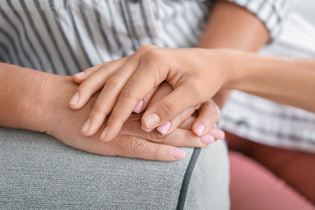 Hands of young woman and her mother. Concept of care and support