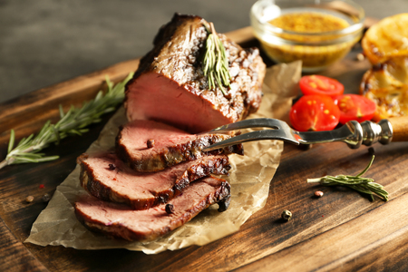 Sliced tasty steak on wooden boardの写真素材
