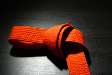 Orange karate belt on dark backgroundの写真素材
