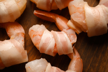 Bacon-wrapped shrimps on wooden background, closeupの写真素材