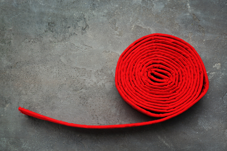 Red karate belt on grey backgroundの写真素材