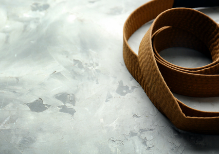 Brown karate belt on grey backgroundの写真素材