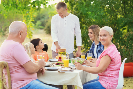 Happy family having barbecue party outdoorsの写真素材