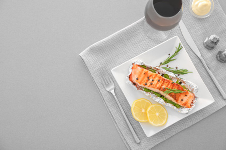 Plate with tasty grilled salmon and lemon slices on tableの写真素材