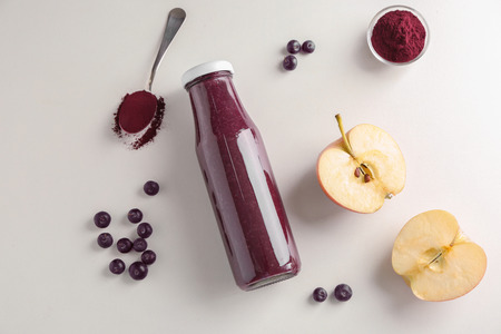 Composition with acai juice in glass bottle on light backgroundの写真素材