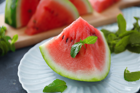 Plate with slice of tasty watermelon on tableの写真素材