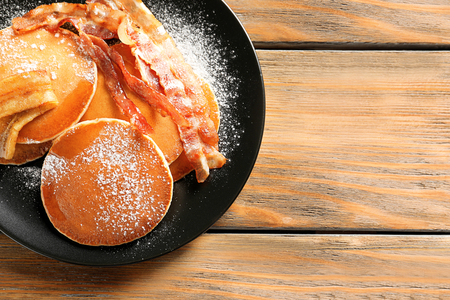 Tasty pancakes with bacon and banana on tableの写真素材