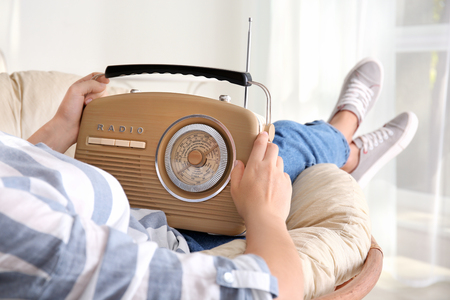 Woman holding radio at homeの写真素材
