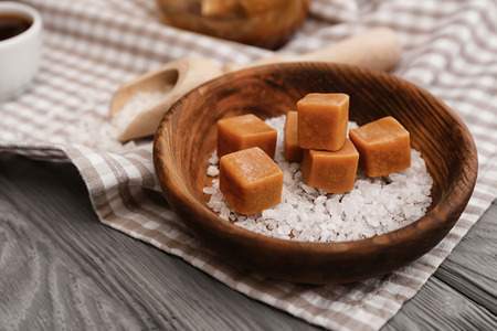 Plate with tasty caramel candies on tableの写真素材